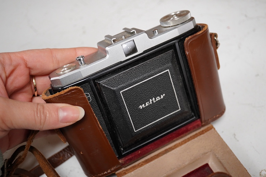 A Leica Model II camera in its original leather case, No. 204618, together with four additional cameras; a Zeiss Ikonta, a Zeiss Nettar, a Prinzflex 500E, and an Ensign Midget camera in its original card box with instruc